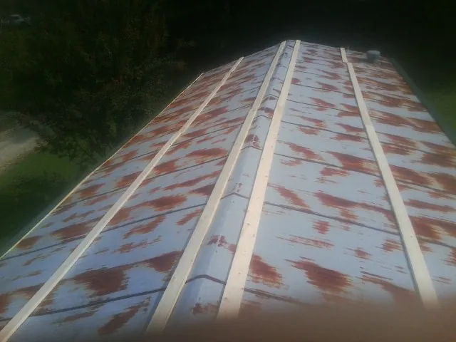 Rusted metal roof panels with new wood purlins before replacement — Storm Damage Roof Repair in Crystal River by Roofing Brothers